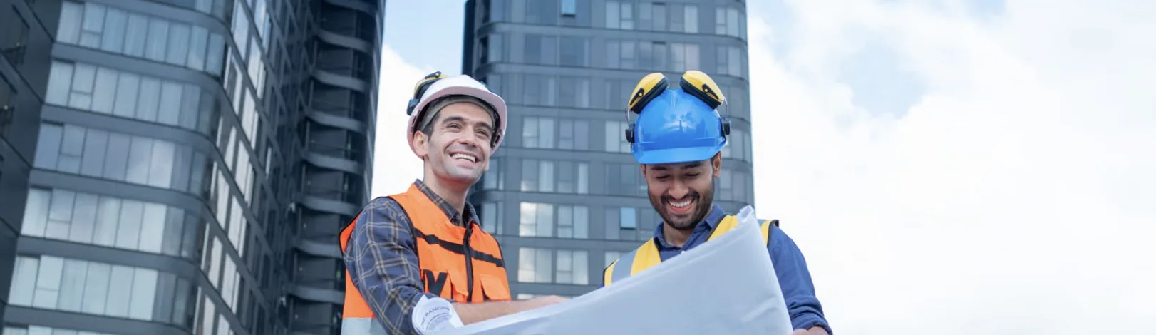 Two construction professionals reviewing blueprints on site